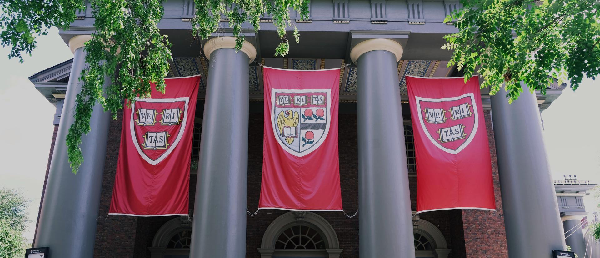 Memorial Church, a Harvard building with 4 large columns with Harvard logo banners in between each column
